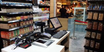 Sprzedawczyni sprawnie nabija kolejne produkty i wydaje klientom paragony z kasy fiskalnej