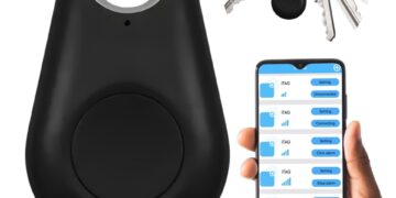 Srebrny pęk kluczy z niebieskim lokalizatorem bluetooth bezpiecznie spoczywa na szklanym stoliku