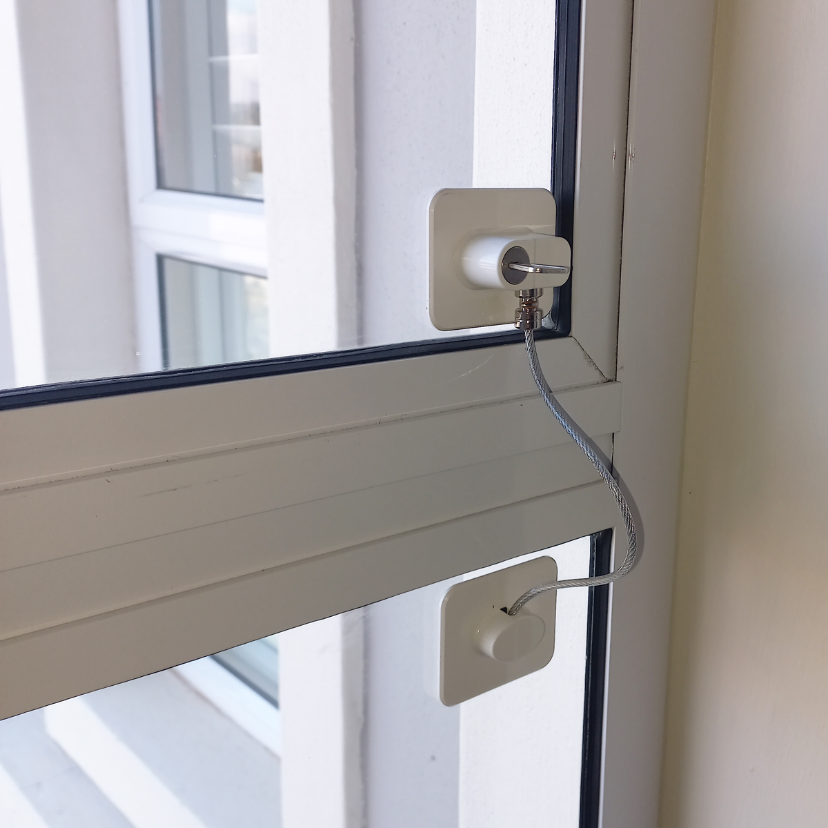 Ręce rodzica wkręcające śruby blokady do framugi okna PCV