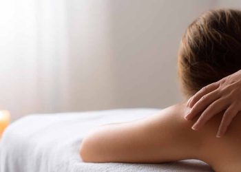 Osoba relaksuje się na stole masażu podczas profesjonalnego masażu pleców w spa