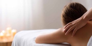 Osoba relaksuje się na stole masażu podczas profesjonalnego masażu pleców w spa