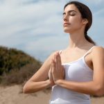 Osoba leżąca w łóżku z zamkniętymi oczami głęboko oddychająca w relaksie przed snem