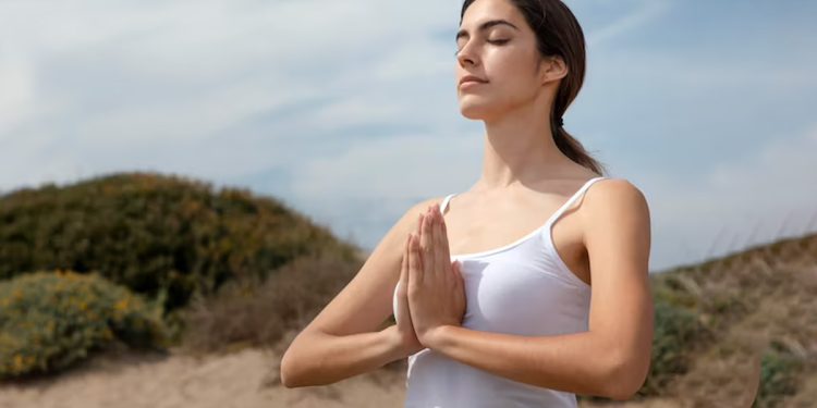 Osoba leżąca w łóżku z zamkniętymi oczami głęboko oddychająca w relaksie przed snem