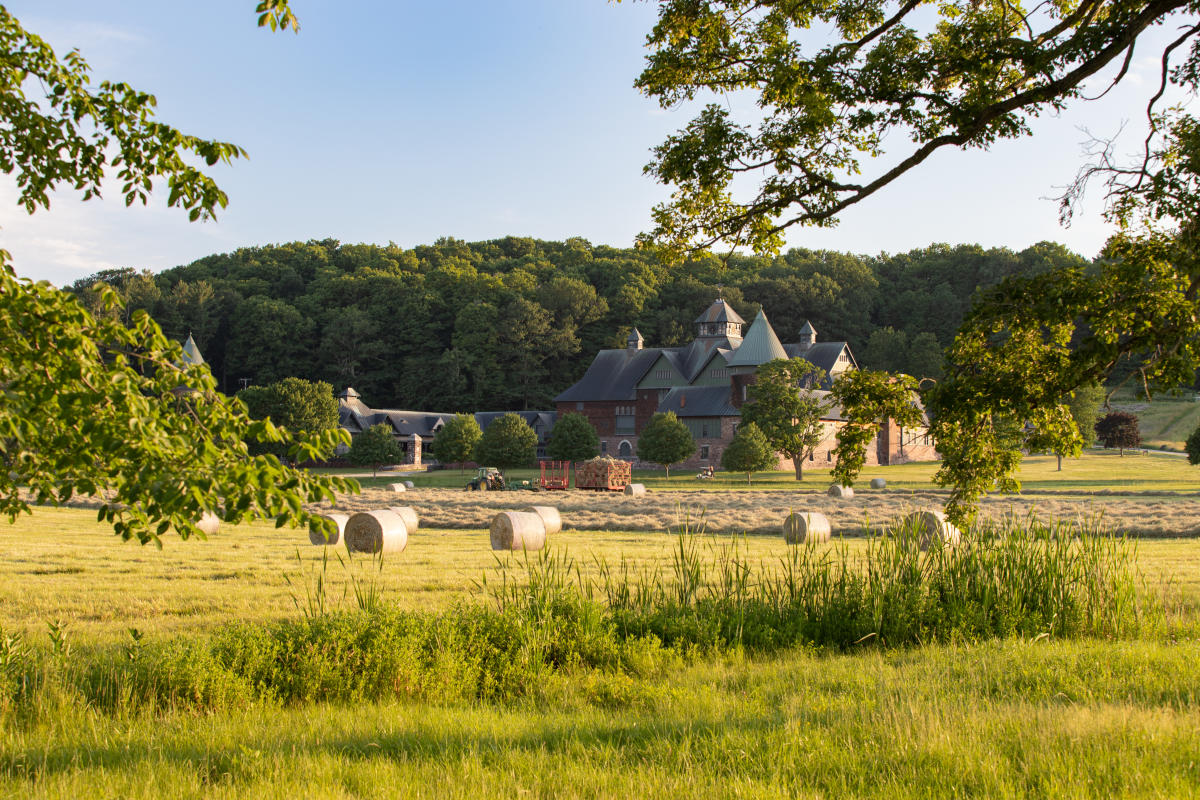 Rodzina je kolację przy długim stole w jadalni z widokiem na pola