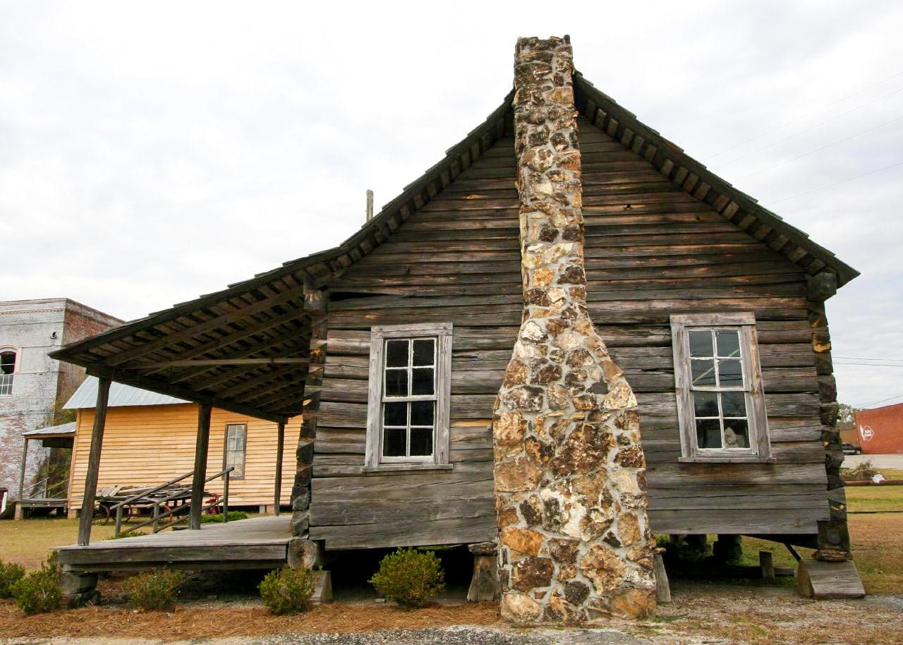 Rodzice pakują kartony i meble do dużej ciężarówki przed blokiem miejskim
