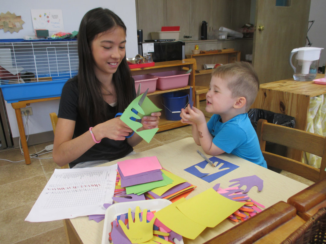 małe dziecko maluje kolorowy obraz farbami akwarelowymi na sztaludze w pokoju