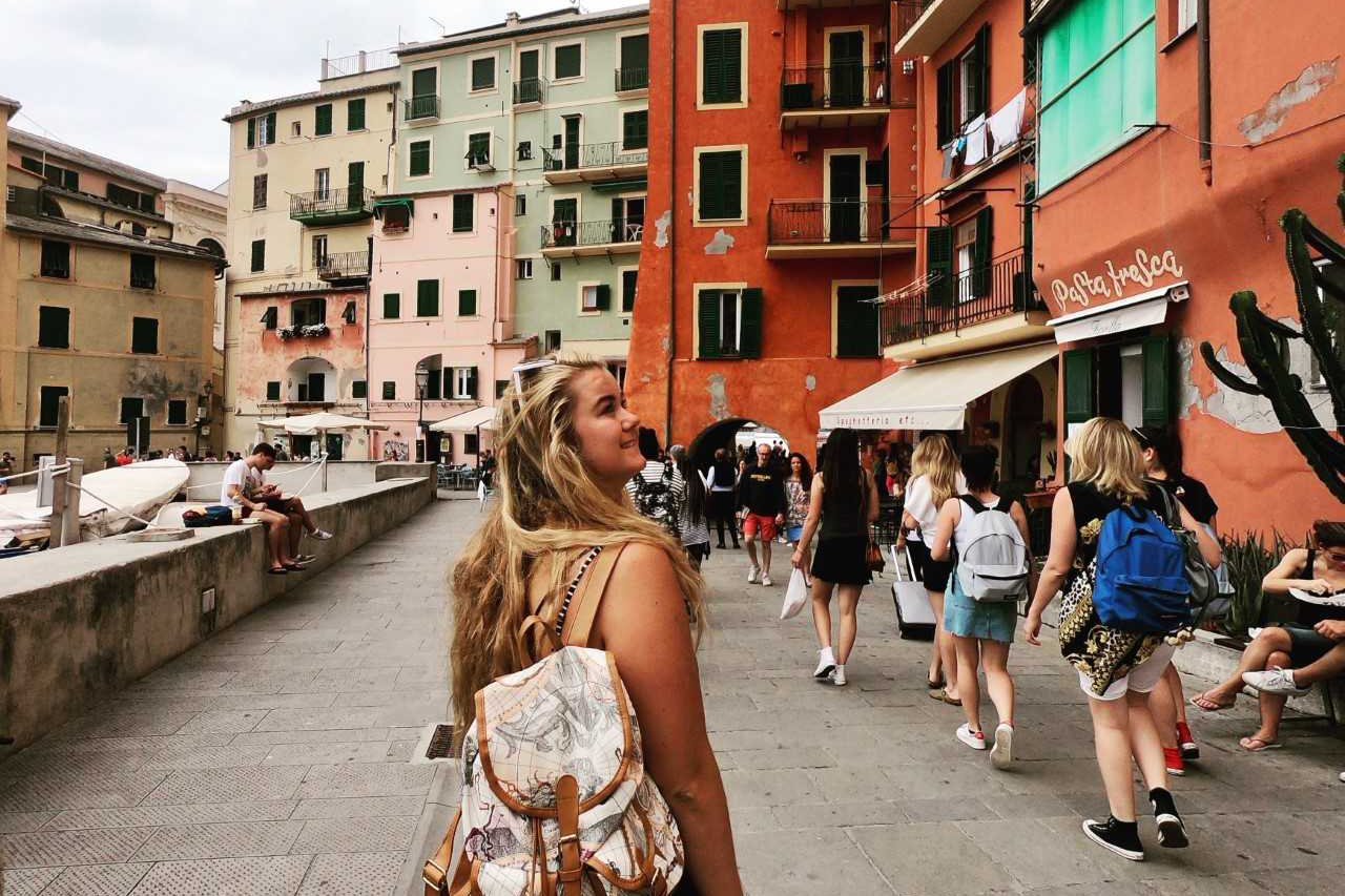 nastolatek pakuje ubrania i książki do dużej walizki w swoim pokoju