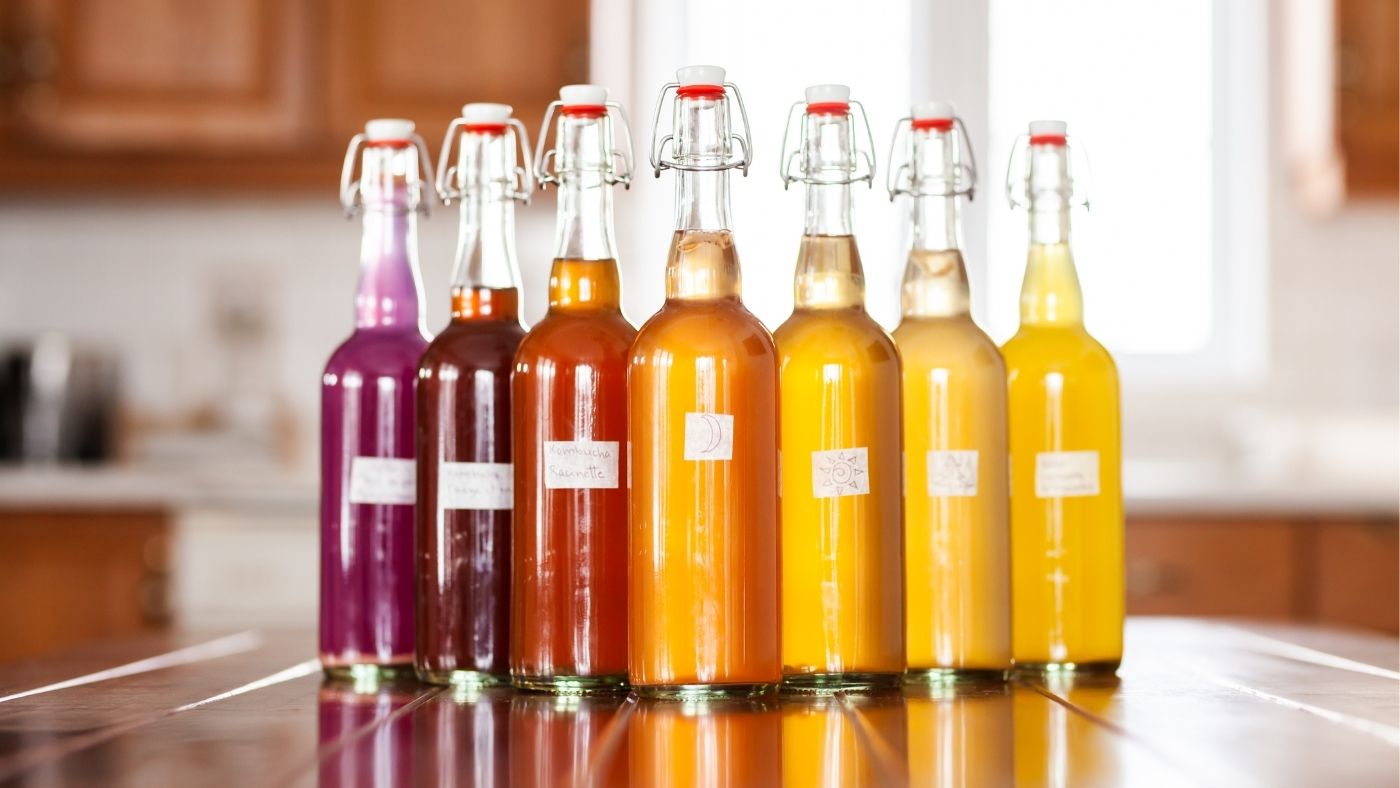 Czarna herbata parująca w dużym szklanym dzbanku obok kubka cukru