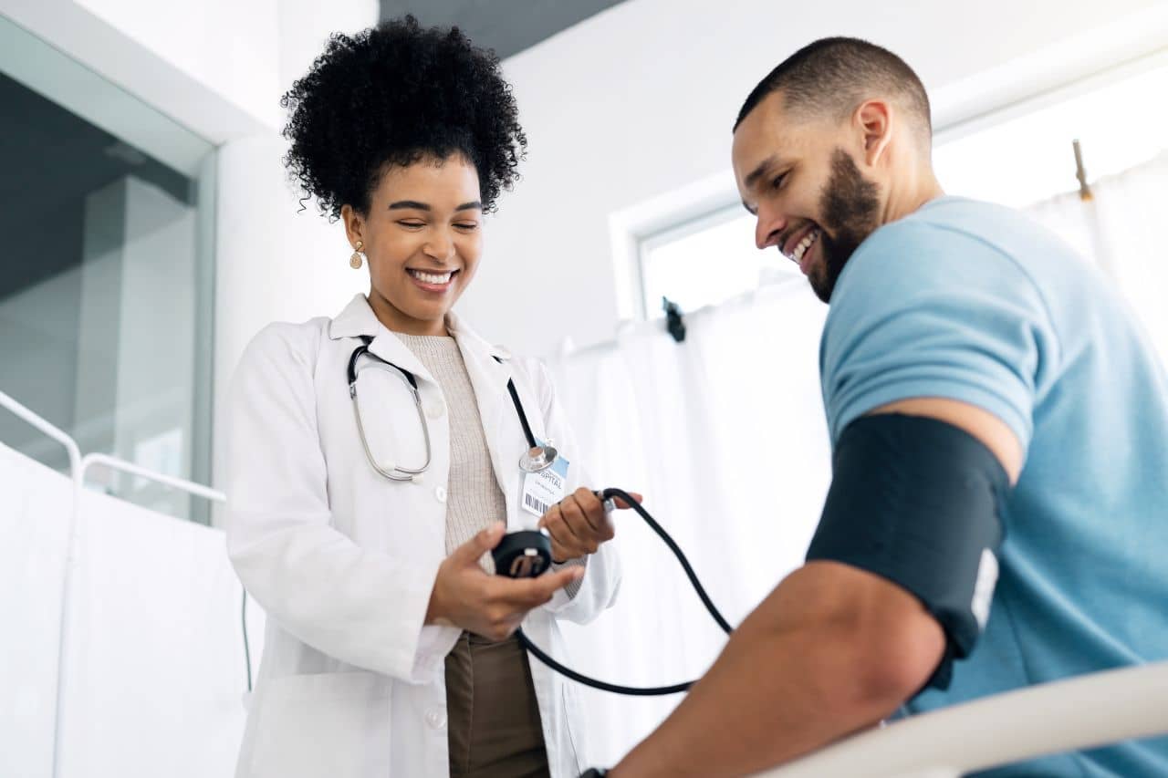 pracownik dostosowujący ergonomiczne krzesło przy komputerze w biurze