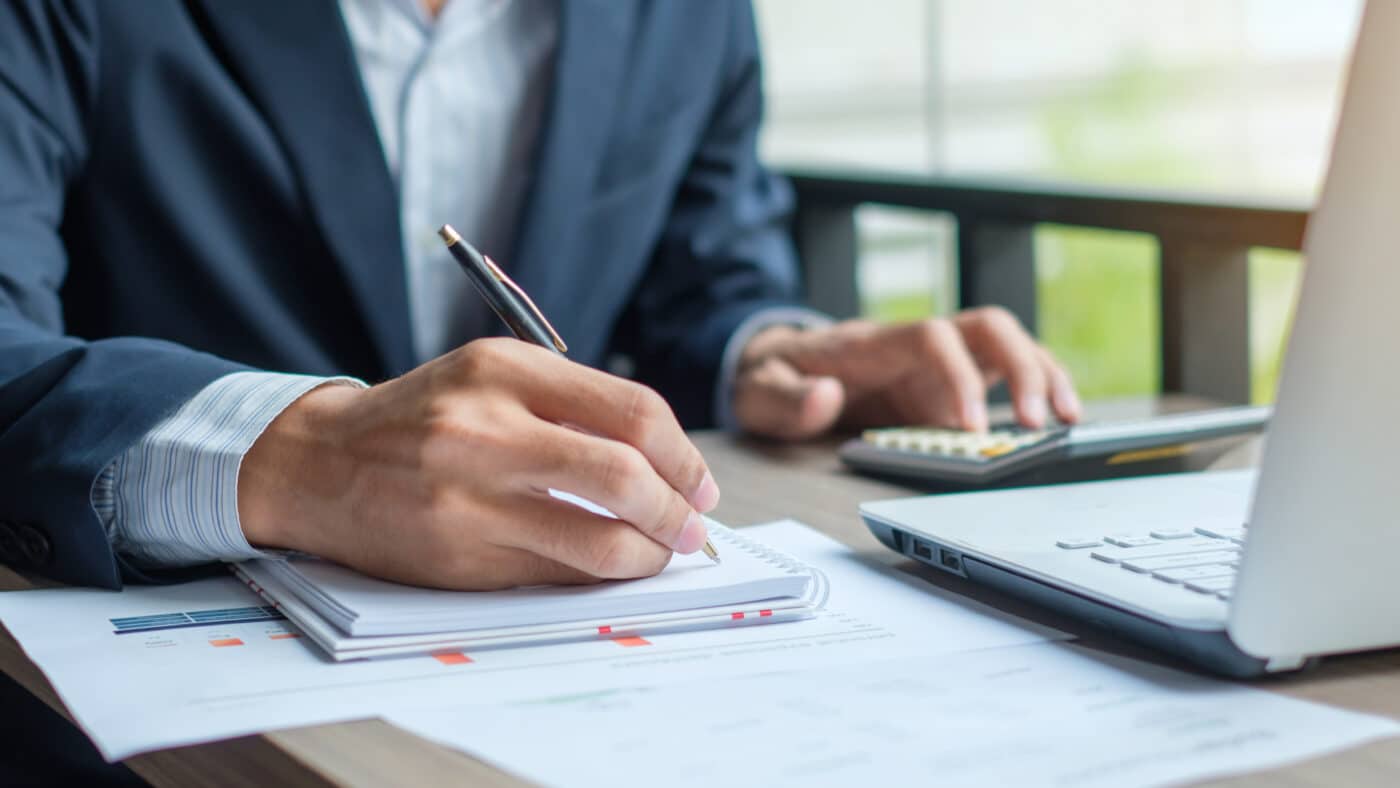 Tradycyjne biuro rachunkowe pełne papierowej dokumentacji Księgowa w biurze otoczona stosami papierów i segregatorów z dokumentami