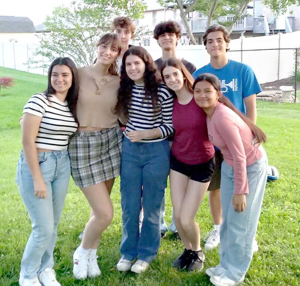 chłopiec gra w piłkę nożną z zagranicznymi kolegami na boisku szkolnym