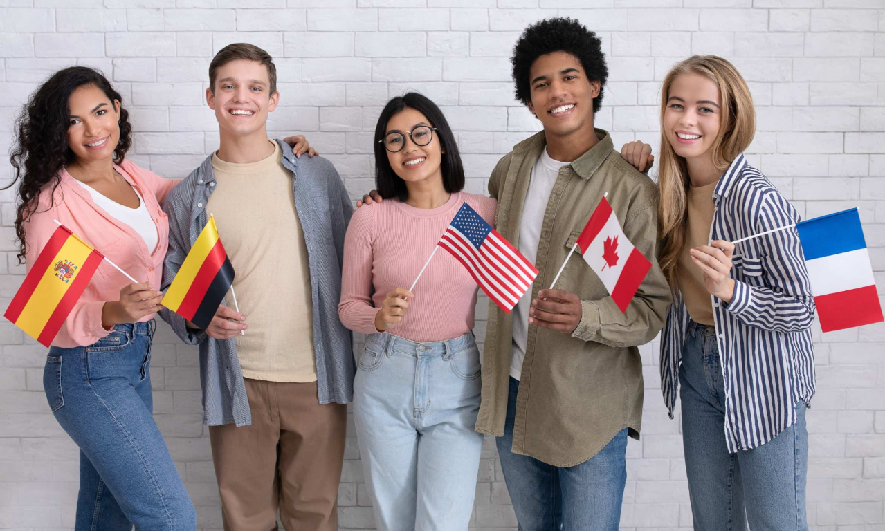 grupa uczniów na wycieczce pieszej w górach z plecakami i flagami