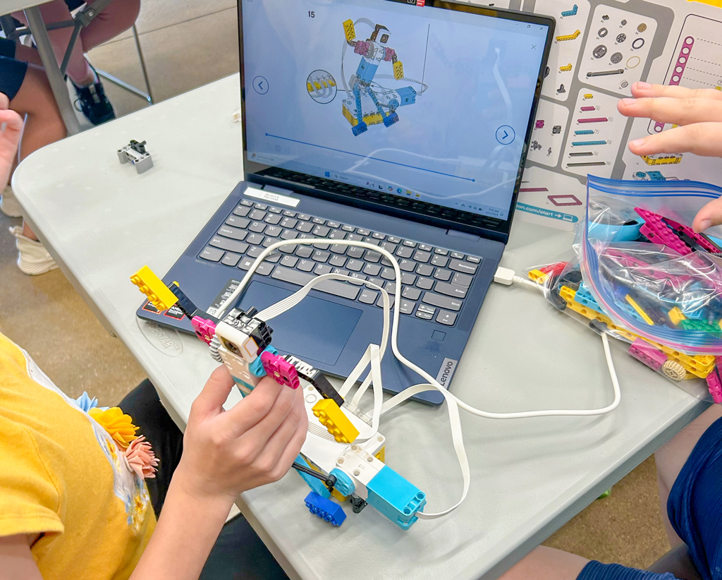 grupa przedszkolaków budująca wieżę z kodujących kostek