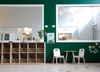 dzieci i nauczyciel w jasnej fińskiej klasie z kolorowymi ścianami