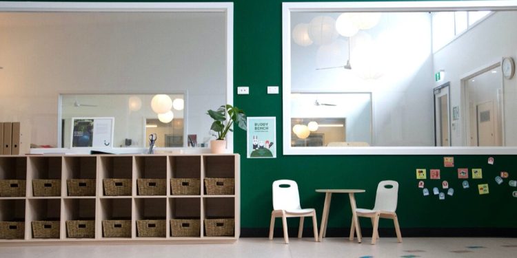 dzieci i nauczyciel w jasnej fińskiej klasie z kolorowymi ścianami