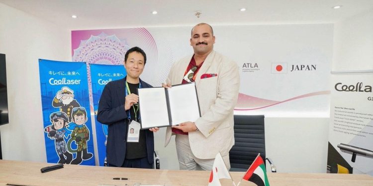 Dwóch biznesmenów w garniturach ściskających dłonie nad stołem z umowami