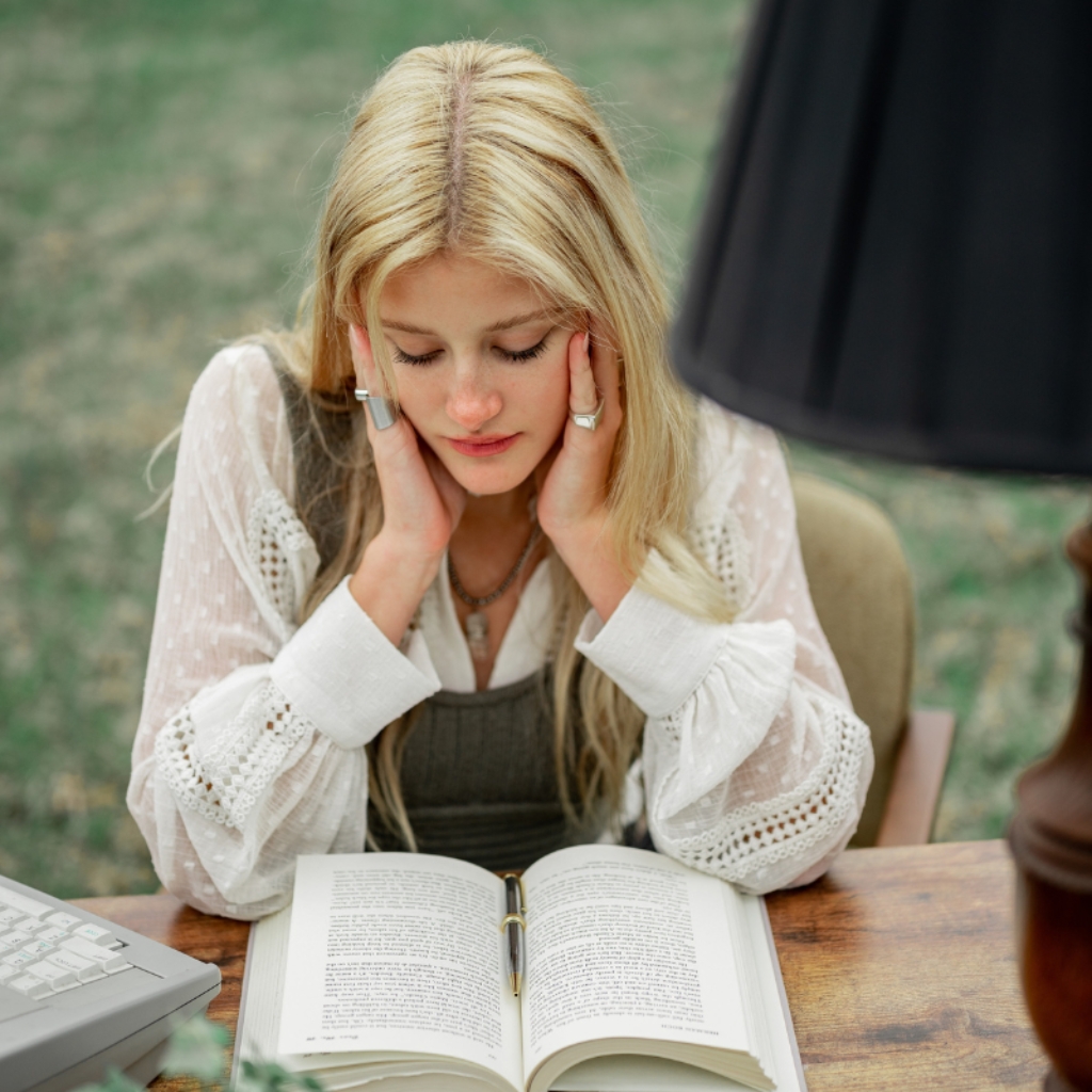 uczeń czyta bez zatrzymywania wzroku na książkę z uśmiechem na twarzy