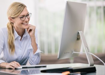 okulary do komputera na biurku z monitorem w tle